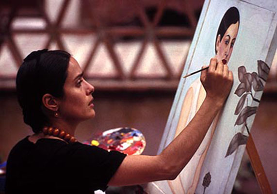 Film still from Hollywood movie Frida: Selma Hayek miming Frida Kahlo painting a self-portrait